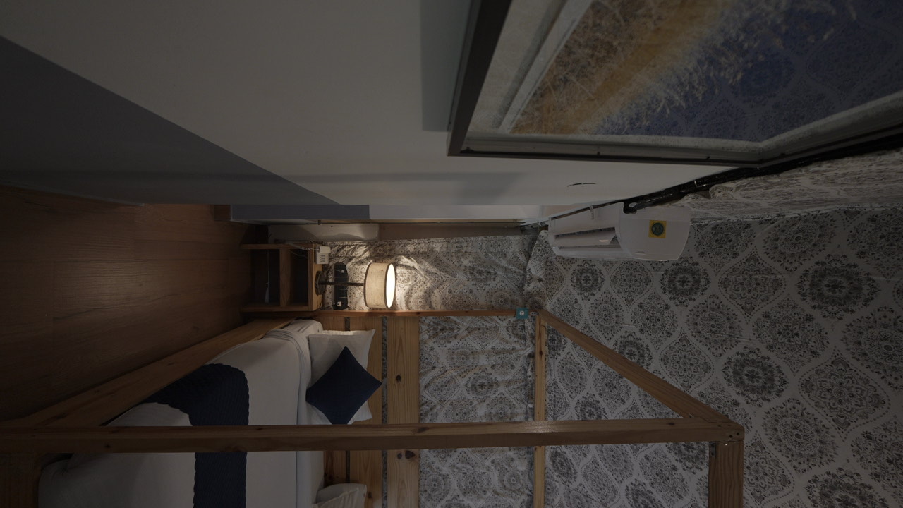 Side view of a cottage bedroom with a wooden canopy bed